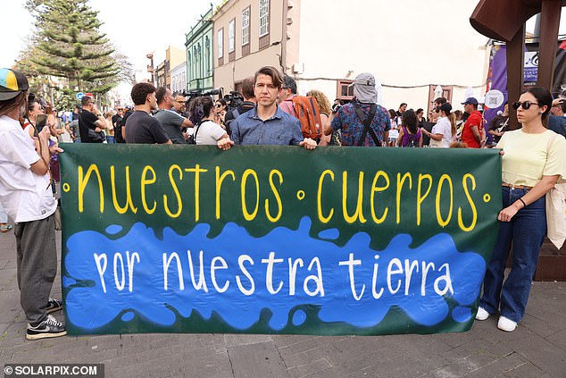 Anti-tourism protesters hold a sign that reads: 