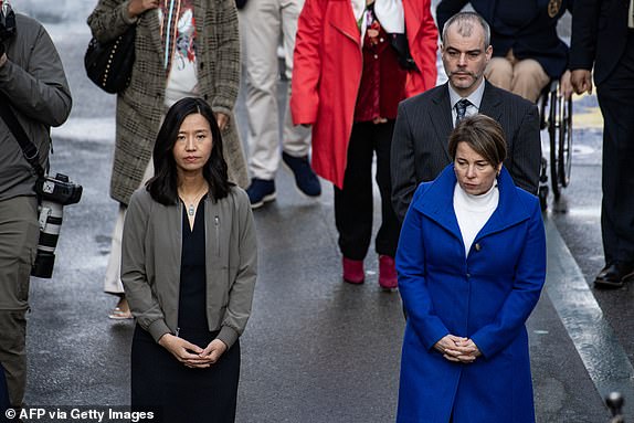 Boston Mayor Michelle Wu (L) and Governor Maura Healey pause and pay tribute to those lost and injured in the 2013 Boston Marathon attacks, before the 128th Boston Marathon, on the 15th April 2024, in Boston, Massachusetts. The marathon includes about 30,000 athletes from 129 countries running the 26.2 miles from Hopkinton to Boston, Massachusetts. The event is the oldest annual marathon in the world. (Photo by Joseph Prezioso/AFP) (Photo by JOSEPH PREZIOSO/AFP via Getty Images)