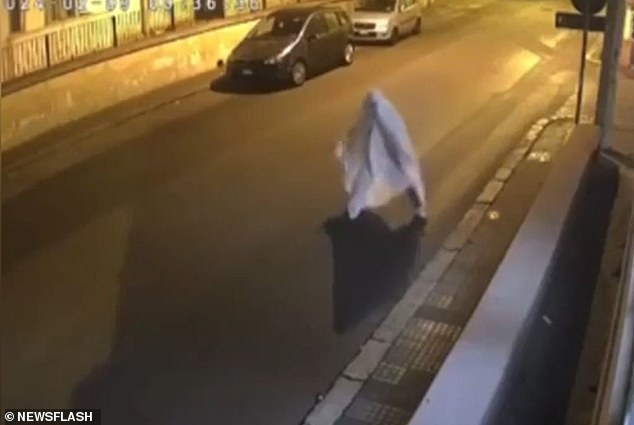 Footage shows him throwing a brick at his window while wearing the sheet.