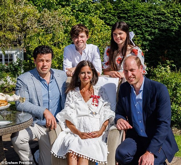 Prince William visited the mother-of-two and her family (pictured) to present her with a damehood in May that year, after she raised millions for Cancer Research UK through her BowelBabe fund.