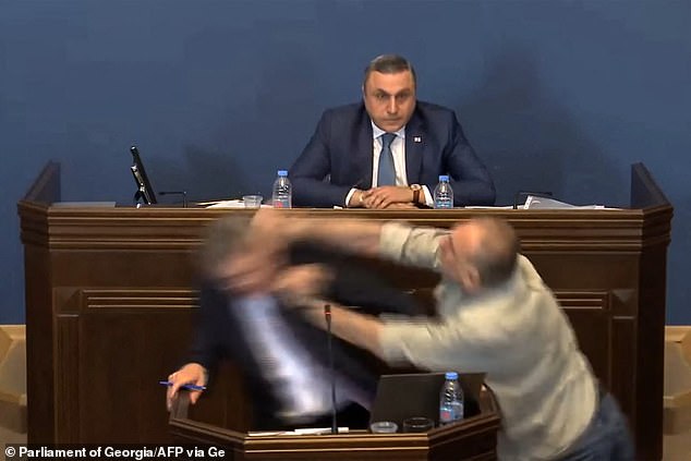 Video of the incident shows the politician, MP Aleko Elisashvili, attacking from the speaker's left, shaking his fist and making contact with the man's face.  Another politician is seen sitting behind the speaker watching, mouth open, in shock.
