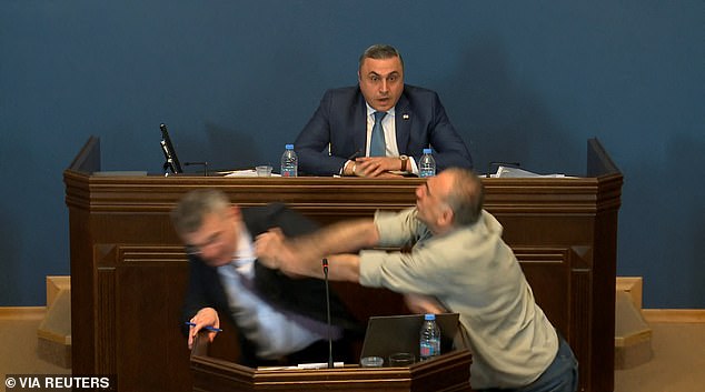 Video of the incident shows MP Aleko Elisashvili, attacking from the left of the speaking politician, shaking his fist and making contact with the man's face.  Another politician is seen sitting behind the speaker watching, mouth open, in shock.