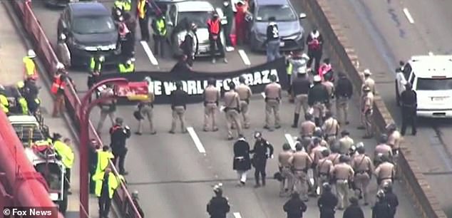 Anti-Israel agitators have blocked traffic on the Golden Gate Bridge and are seen holding a large sign that reads: 