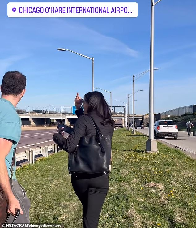 An angry traveler raised her middle finger at protesters as she walked to the airport and shouted: 'Fuck you!'