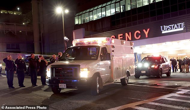 Ambulances transport the bodies of the two officers killed early Monday morning
