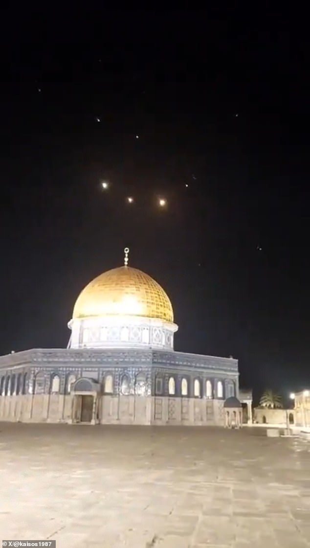Israel today threatened airstrikes against Iran in retaliation for a barrage of 350 missiles amid fears the conflict could escalate into an all-out war in the Middle East.  Pictured: Rocket trails are seen in the sky above the Al-Aqsa Mosque in Jerusalem as Iranian missiles are intercepted by air defenses.