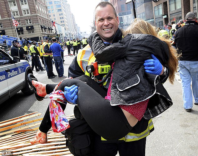 Pictured: Boston firefighter James Plourde carries an injured girl from the scene after an attack near the finish line of the Boston Marathon.