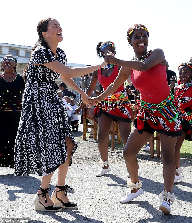 Harry and Meghan's ten-day tour with their son Archie began in Cape Town, South Africa.  Above: Meghan dancing with locals in Nyanga township, South Africa