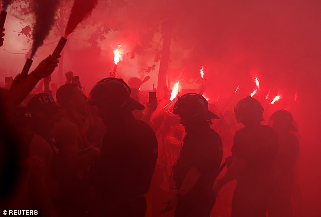 Police were on hand to try to keep supporters away as the road was filled with flare smoke.