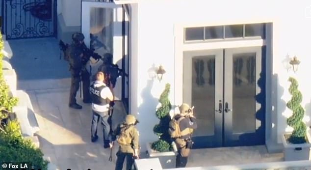 Police were seen outside the huge house as they carefully approached the front door with weapons drawn.  The motive for the invasion is unclear, but police said it was not a random attack on the home.