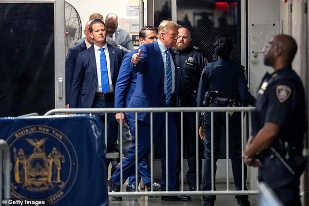 Trump gives a thumbs up as he returns from a break during the second day of his trial.