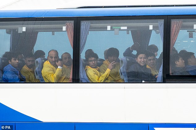 A group of people believed to be migrants appear on a bus in Dover, Kent, yesterday after being rescued by a Border Force boat.