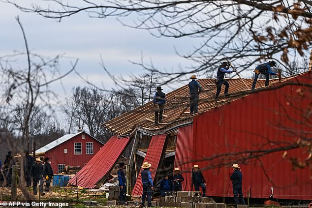 Members of the Amish community repair a destroyed barn in Fulgham, Kentucky