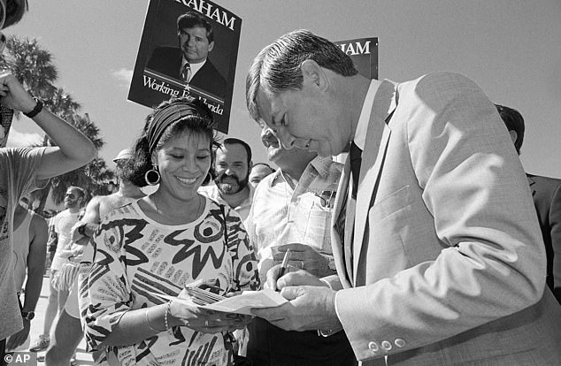 Former Florida Governor Bob Graham (right) signs an autograph for María Dulce before a campaign appearance at the Miami River Festival in Jean Marti Park, October 25, 1986.