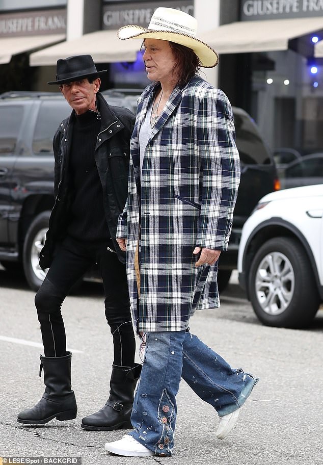 The Oscar-nominated actor stood out wearing a plaid trench coat over a low-cut T-shirt while spending time with his friends.