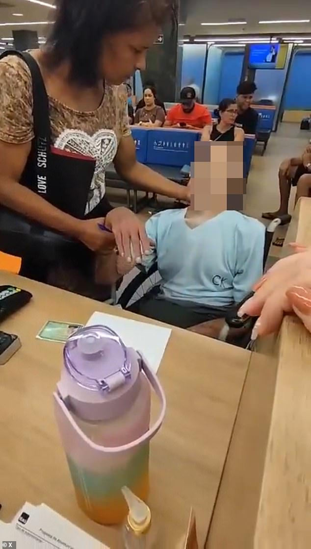 The footage showed the woman telling the dead man to hold onto her pen tightly as she placed it between her fingers and encouraged him to sign a paper at the bank branch in Bangu, a neighborhood in the western part of Rio de Janeiro, Brazil.