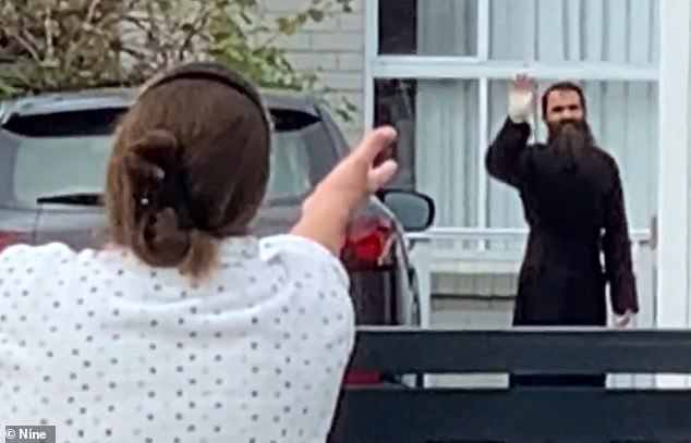 Father Royel was seen walking from the hospital and greeting an excited neighbor with a bandage around his hand on Wednesday afternoon (pictured).