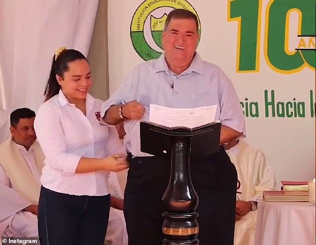 A woman helps the mayor of Sabanalarga, Jorge Chams, adjust the pants that fell down while he was giving a speech