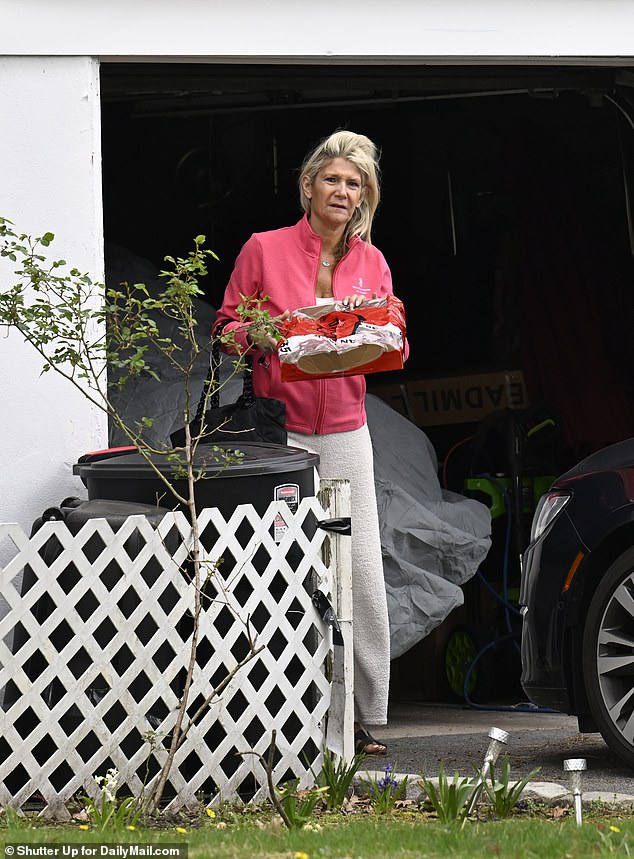 DailyMail.com captured scandal-hit Democratic Senator Bob's wife outside the house tending to plants while wearing yellow Marigold gloves.