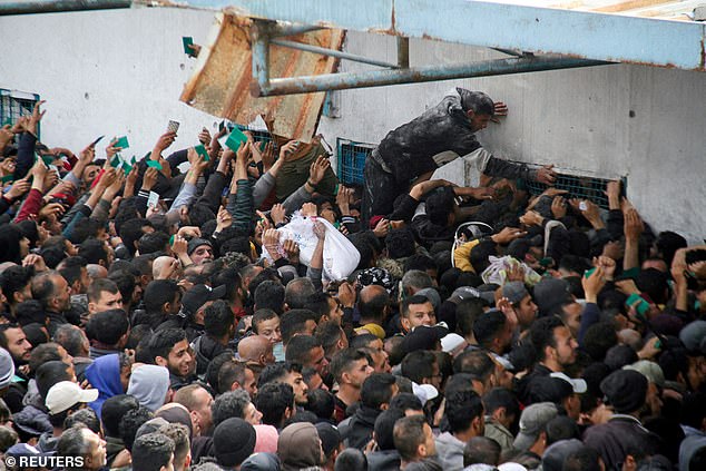 Palestinians gather for aid outside a UNRWA warehouse as Gaza residents face critical levels of hunger, March 18, 2024.