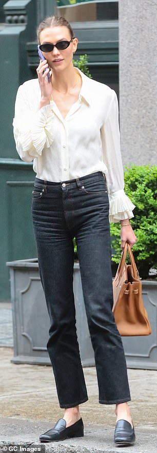 She paired her cream top with simple black jeans that reached her ankles.