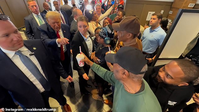 Trump (pictured handing out milkshakes) made a surprise visit to the fast food restaurant, where he told a dozen employees behind the counter: 