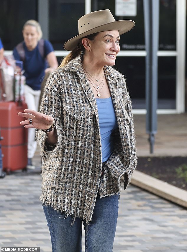 Returning to Sydney, Michelle looked stylish in a blue vest and jeans, which she teamed with a brown tweed jacket.