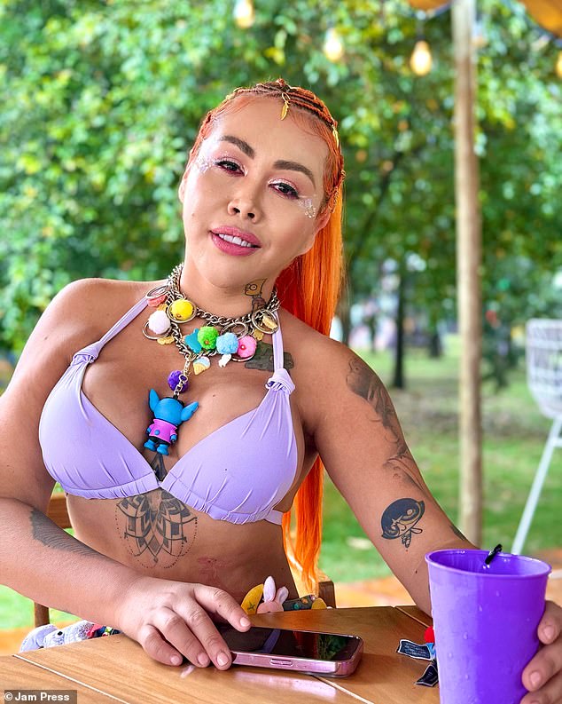 The Colombian beauty is also famous for her numerous plastic surgeries.  In the photo above, she is sporting a lilac bikini and holding a matching purple cup, sporting tattoos on her upper body.
