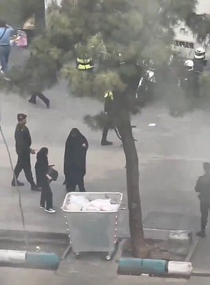 An alleged morality policeman is seen arguing harshly with a woman on the street before leading her towards a van, even though she appears to be wearing a hijab.