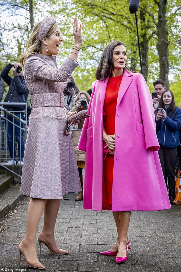 Queen Máxima excitedly greets someone while Letizia poses for the cameras