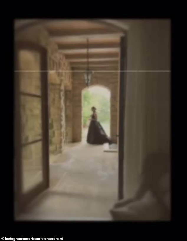 The video continues with an image of a woman in a long dress, backlit in a hallway.