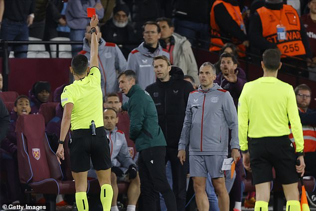 Referee José María Sánchez brandishes the red card after the staff altercation on the sideline