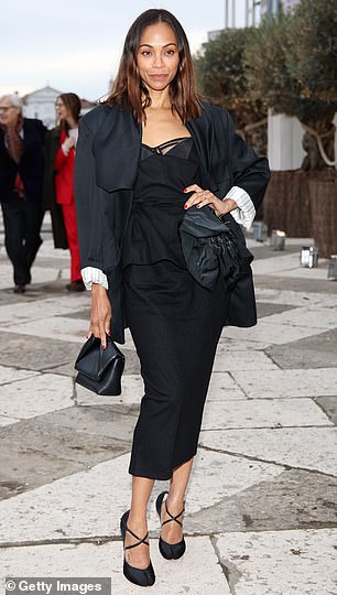Zoe looked chic in a black midi dress that had a large embellishment on the left side and contained a hemline that hit a few inches above her ankles.