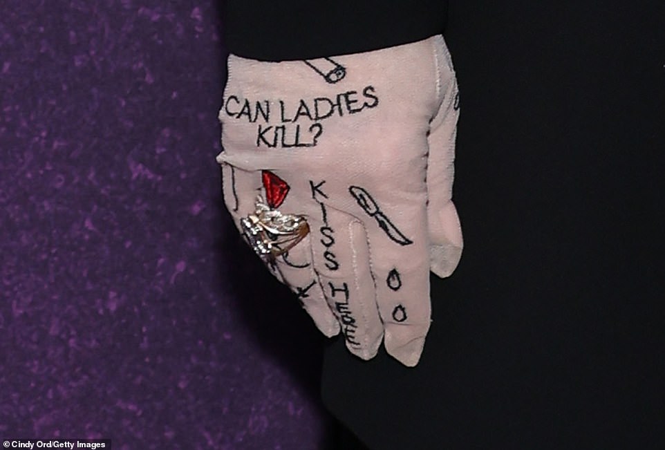 Melissa completed her look on Thursday with some 'tattooed gloves' that read: 'Can Women Kill?'