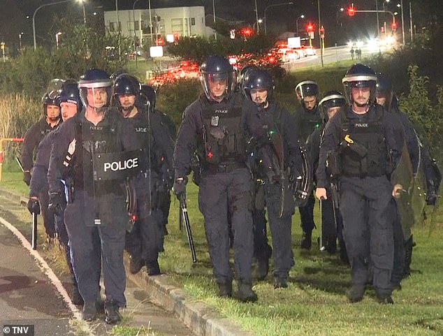 An angry mob of thousands were involved in a series of intense clashes with police in Wakeley, near Fairfield, on Monday night.  The agents are photographed at the scene.