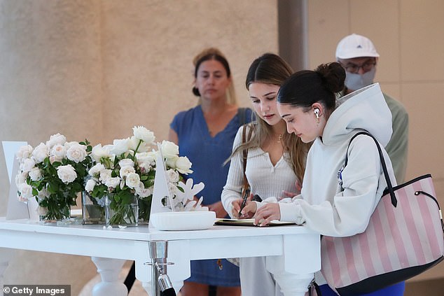 Shoppers sign a book of condolence during the reopening of the Westfield Bondi Junction shopping center on April 19.
