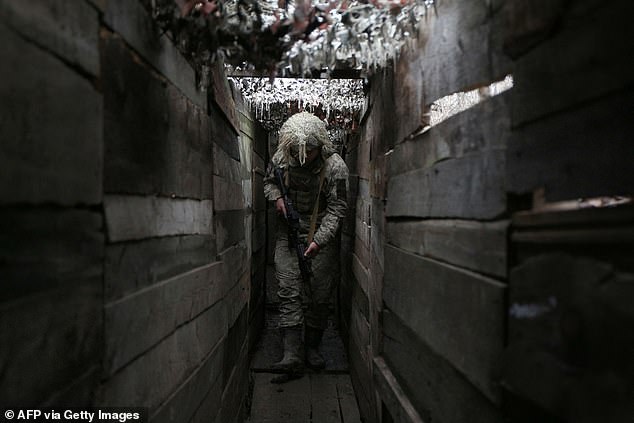Ukrainian soldier walks through a trench on the front line with Russian-backed separatists, not far from the town of Avdiivka, Donetsk region, on December 10, 2021.