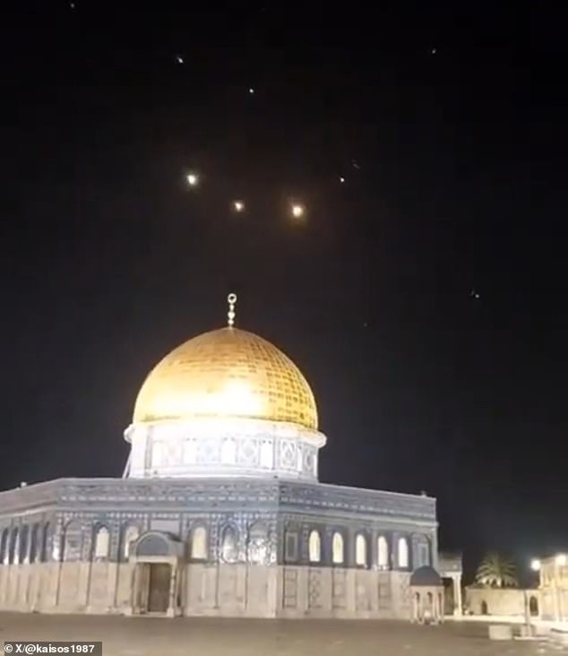Rocket trails are seen in the sky above the Al-Aqsa Mosque in Jerusalem as Iranian missiles are intercepted by air defenses.