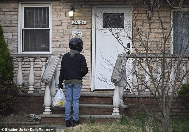 A delivery man waits in front of the house after the squatters inside asked for food.