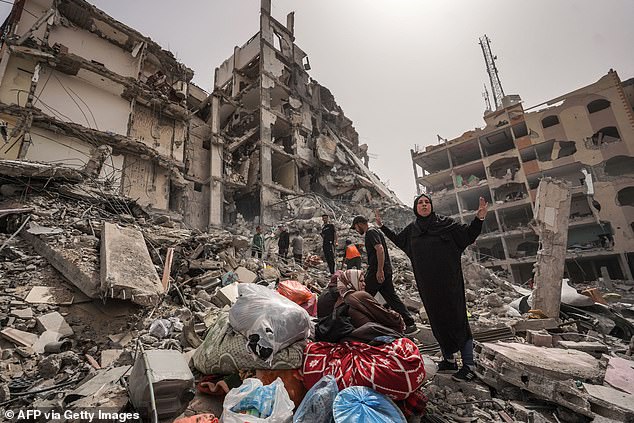 Palestinians inspect damage to a building in the town of Nuseirat, central Gaza Strip, April 18.