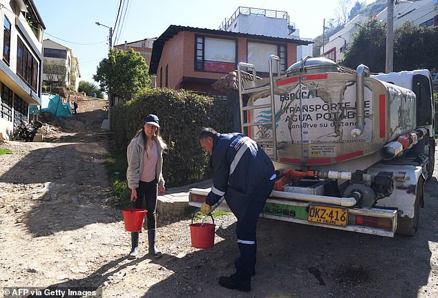 A resident collects water from a tanker truck in La Calera, a city near Bogotá, the capital of Colombia.