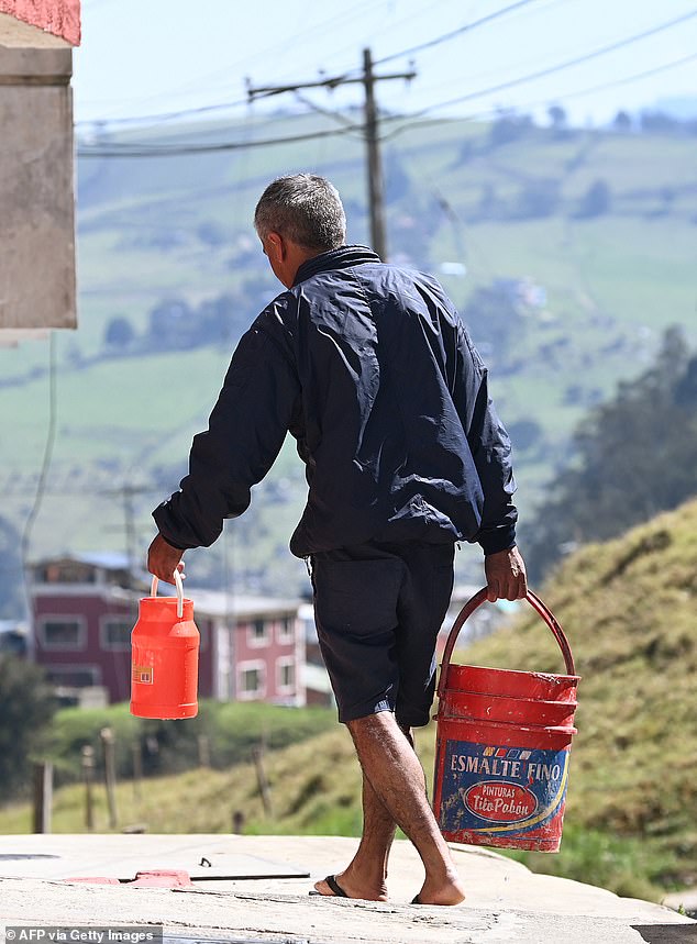 A resident of La Calera, a city north of Bogotá, capital of Colombia, carries water to his house. The area suffers from water shortages as its main reservoirs have been compromised by the drought that has been going on for several months.