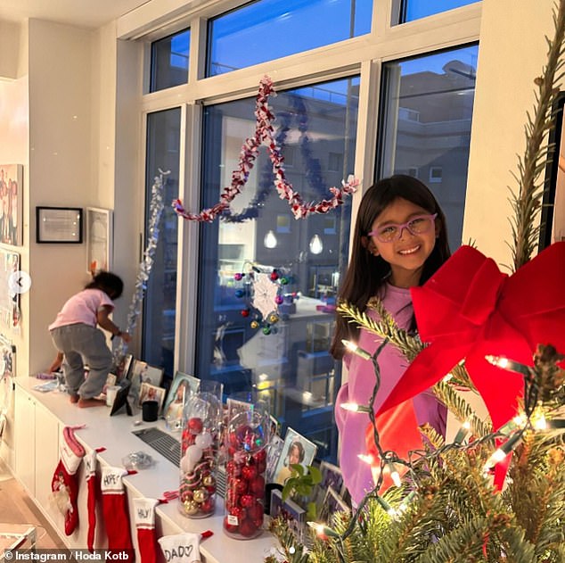 At Christmas, Hoda decorated her window sills with ornaments and stockings while her daughters helped remove tinsel from the window.