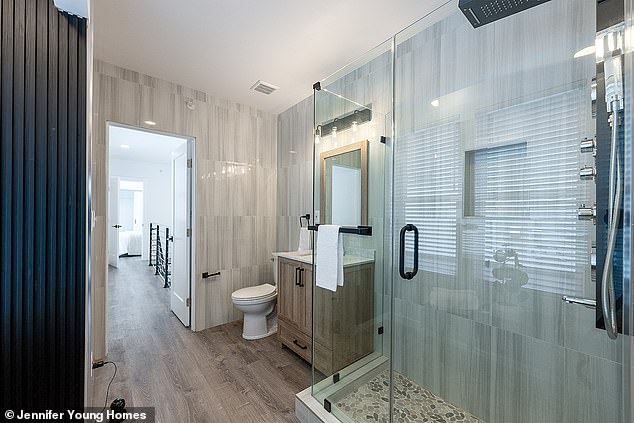 The bathroom, which looks large but deceptively small, has a large glass shower with cobblestone floor and stunning wood finishes.
