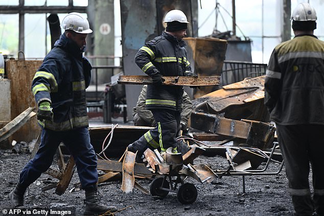 Rescuers and workers clear debris in a turbine hall filled with burned equipment at a power plant of energy provider DTEK, destroyed after an attack, at an undisclosed location in Ukraine on April 19, 2024.