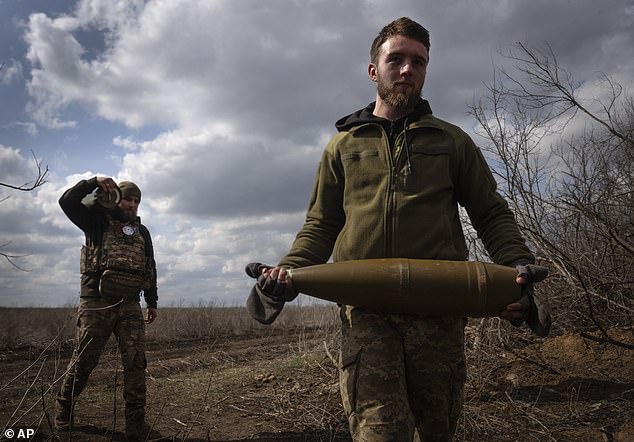 Ukrainian soldiers carry shells to fire on Russian positions on the front line.