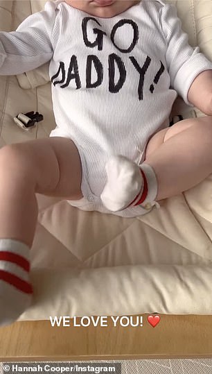 The little one could be seen kicking his feet in stockings while wearing a baby t-shirt that said 