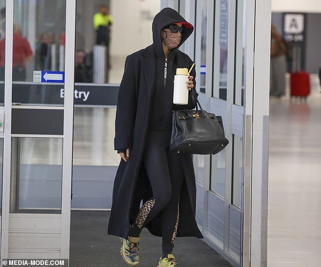 Additionally, he concealed his identity with a long black coat and a matching PE Nation hoodie. The pop star also wore a pair of tights with leopard print on the side.