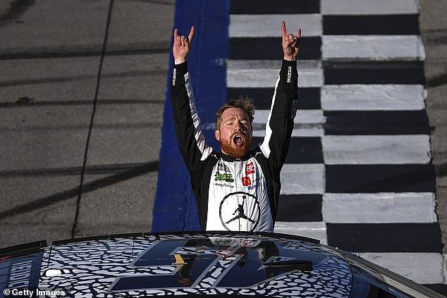 Reddick celebrates with his car on the track after winning the NASCAR Cup Series GEICO 500