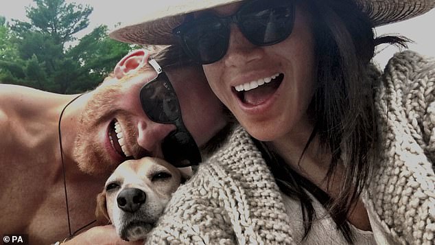 Harry and Meghan appear in the photo with their pet Beagle Guy